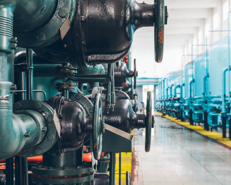 Interior storage tanks connected by large metal pipes and valves.