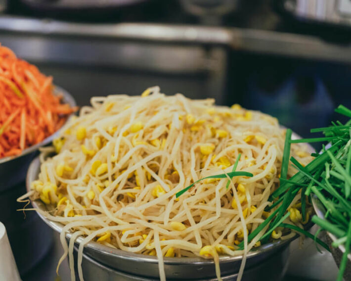 Bowl of noodles and corn in stainless steel colander.